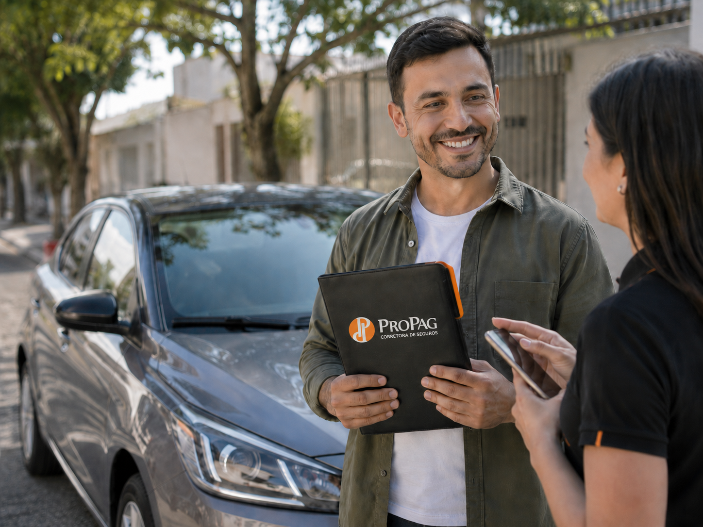 Consultor da ProPag atendendo cliente segurado ao lado do carro